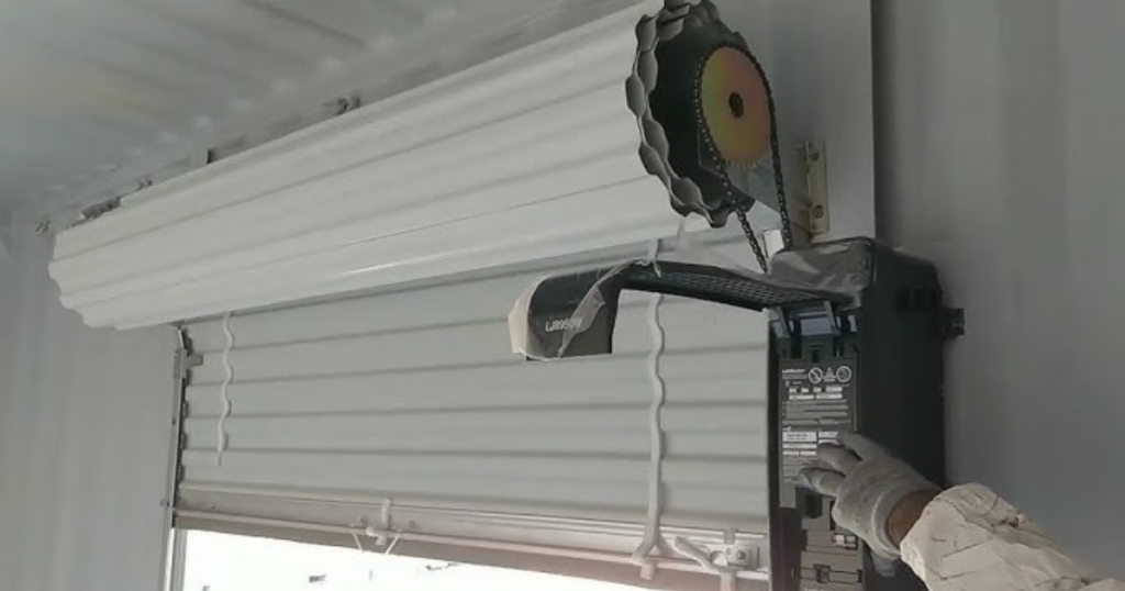 Gloved hand programs garage door motor box.